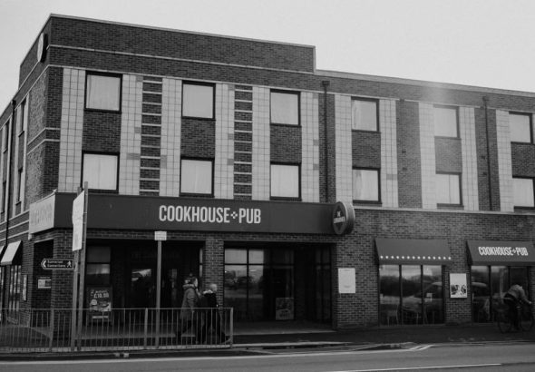Black and white image of Cookhouse & Pub, Rhyl, showcasing urban architecture.